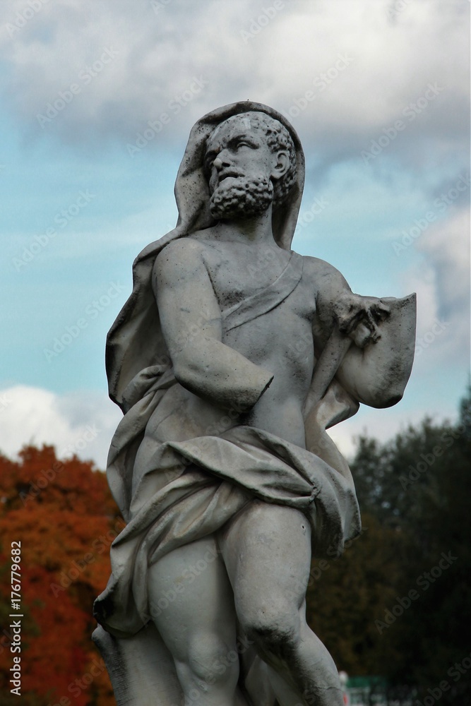 An old sculpture of white marble in the city park.  City park sculpture