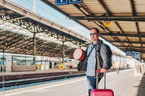 Man tourist standing on a platform of a train station