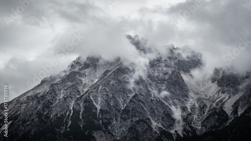 Gray rocky mountain in clouds © mart