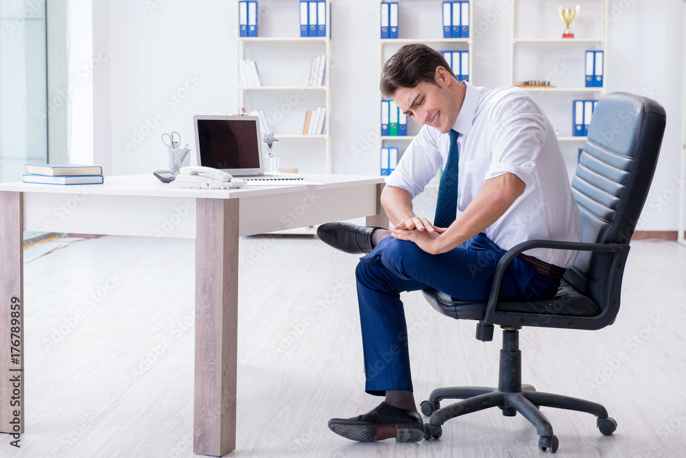 Young businessman doing sports stretching at workplace Young businessman doing sports stretching at workplace