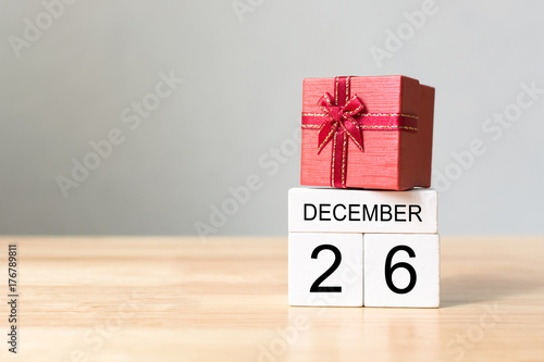 Wooden block calendar 26 December and red color gift box on wood table with white wall background, Happy boxing day sale concept, Copy space your text
