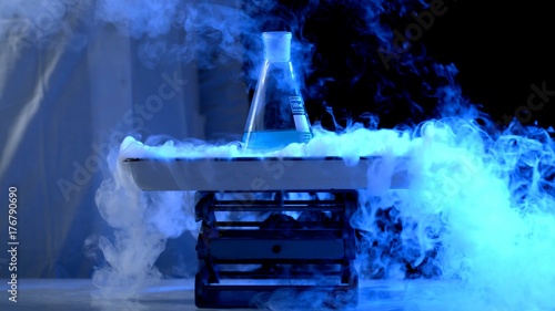 Bottle and liquid nitrogen in a laboratory. Chemical experiment. Flask with water and dry ice boiling chemical experiment