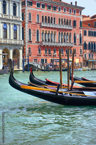 Gondolas in front of old houses by Canal Grande in a summer day in Venice