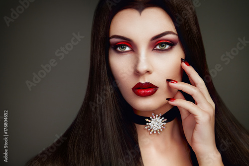 Halloween Vampire Woman portrait. Beautiful Glamour Fashion Sexy Vampire Lady with long dark Hair, beauty make up and Costume
