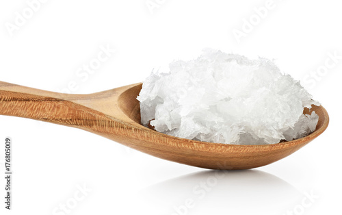 Wooden spoon with coconut oil isolated on white background.
