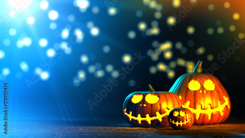 3 difference Halloween pumpkins on wood floor with blur bright light on dark blue background.