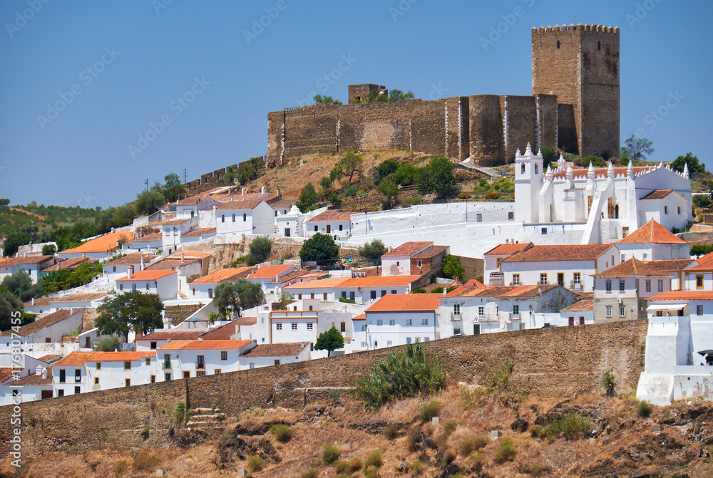 The mediaeval castle on the top of the hill surrounded by residential houses of Mertola. Portugal