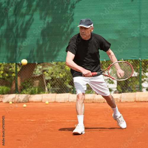 Senior Man Playing Tennis © Microgen