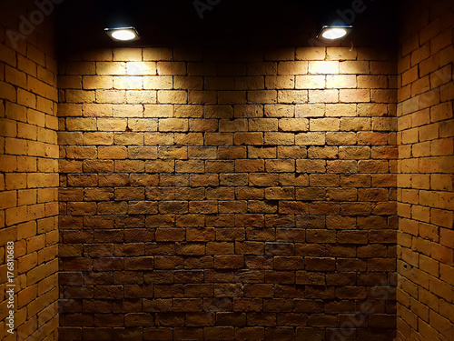 abstract old brick wall in the dark with two spotlight, warm light tone. brick wall in empty room. brick wall background for wallpaper