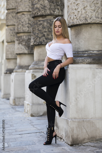 Young woman wearing black jeans and white belly top