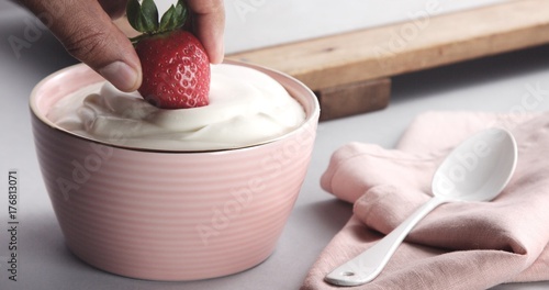 Bild auf Leinwand mixed race man's hand get wet strawberry in a cream