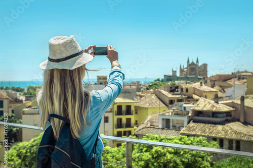 Woman tourist with her phone camera in hands shooting in Palma d