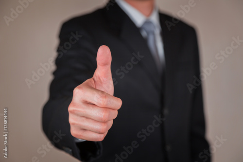 Businessman give a thumbs up for compliment as praise, congratulate, good and like concept.