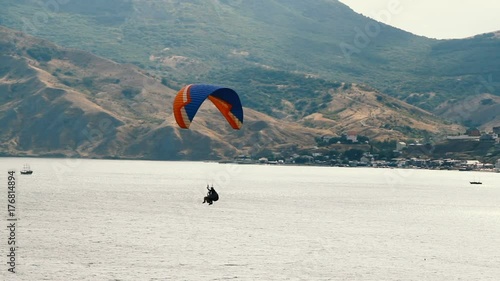 paragliders fly over the coastal village