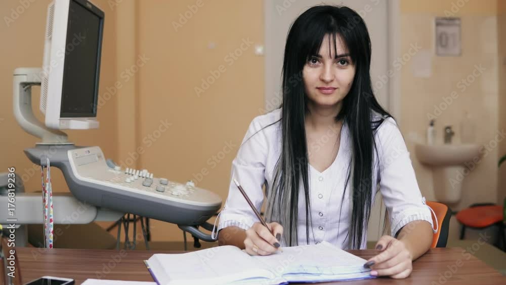 Young female doctor sitting at the desk and writing prescription and filling the forms in clinic, filling out health insurance claim form, completing medical info. Healthcare and medicine concept Young female doctor sitting at the desk and writing prescription and filling the forms in clinic, filling out health insurance claim form, completing medical info. Healthcare and medicine concept