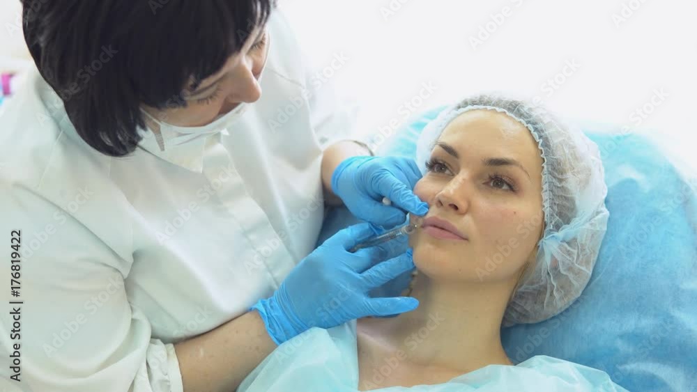 Facial rejuvenation procedure - an unknown woman doctor injects botulinum toxin injection to young woman Facial rejuvenation procedure - an unknown woman doctor injects botulinum toxin injection to young woman