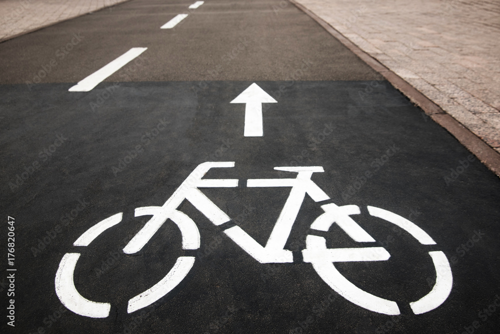 Fototapeta premium Bicycle white sign or icon on the asphalt road in the city