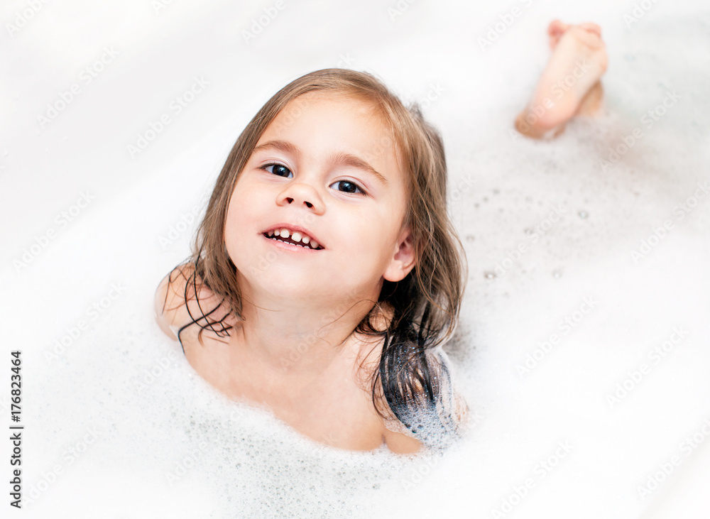 Happy little child girl is taking a bath with a foam Stock Photo ...