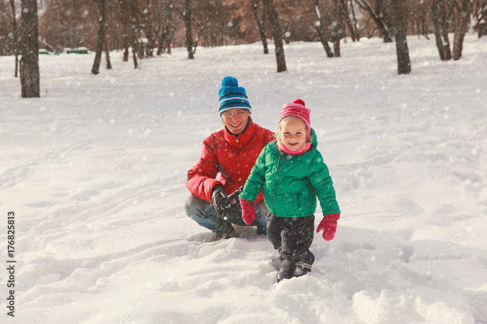 father and little daughter play in winter snow father and little daughter play in winter snow