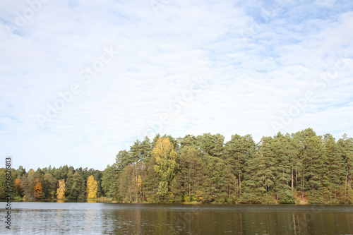 Farmside view of small countryside lake in the middle of forest in autumn. © Artūrs Stiebriņš
