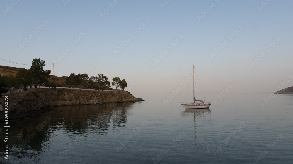 Fototapeta premium Reflet d'un voilier dans l'eau dans une baie