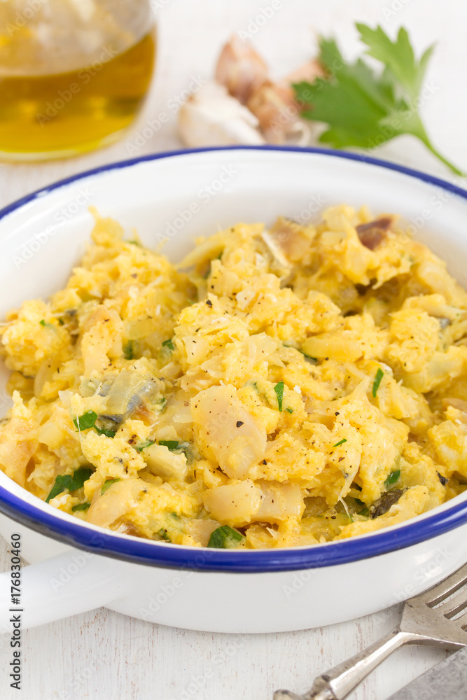 cod fish with egg and herbs on white dish cod fish with egg and herbs on white dish