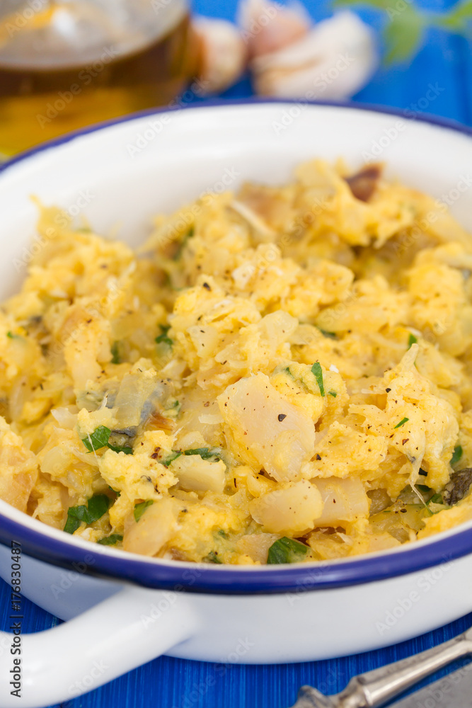 codfish with egg and herbs on white dish