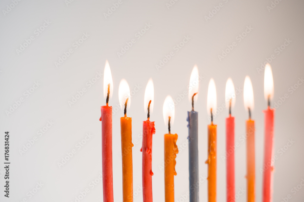 Multi-colored lighted candles on chanukiah closeup Multi-colored lighted candles on chanukiah closeup