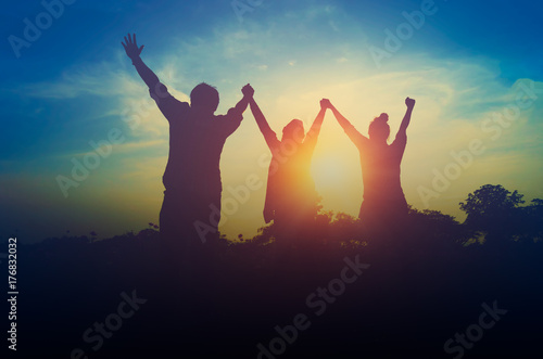 Silhouette of happy teamwork hold hands up as a business successful, business victory photo