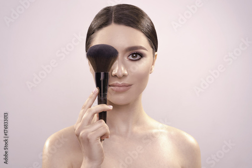 beautiful portrait of a pretty woman with fresh clean skin and nude make up. brush near face. high quality image.
