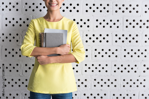 Cheerful elegant girl is posing with copybooks photo