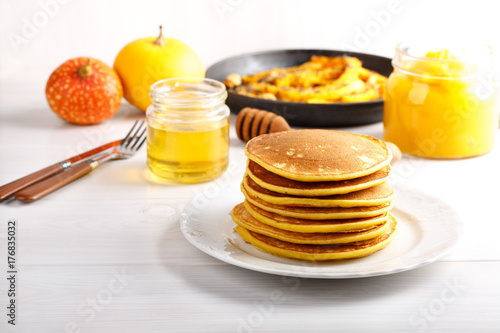 Stack of homemade pumpkin pancakes on white table