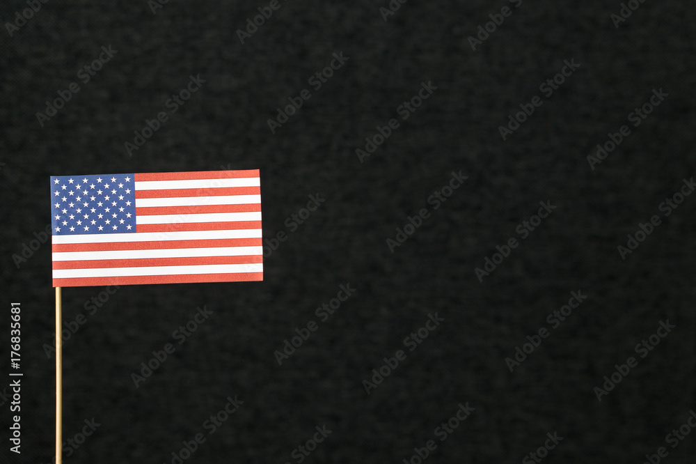 Obraz premium The flag of United States of America (USA) made from paper on wooden stick against dark background with negative copy space for text.