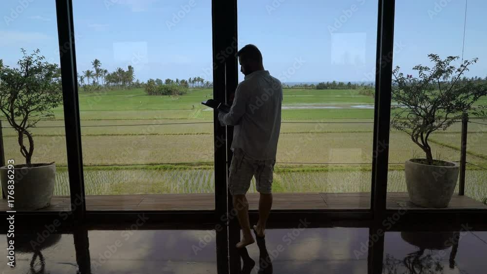 Man going on the terrace and browsing internet on tablet, steadycam shot
Man going on the terrace and browsing internet on tablet, steadycam shot