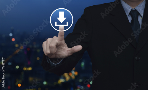 Businessman pressing download icon over blur colorful night light city tower, Business internet concept