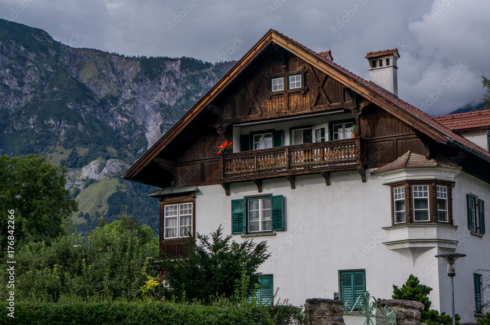 House in Tirol style in Alps Austria at summer, mountains background.