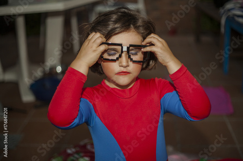 Portrait child dressed with spiderman costume and glasses accesory.