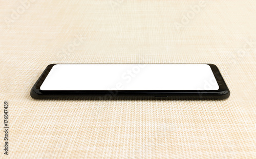 Black smart phone with white screen on the wooden table