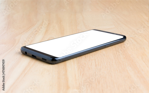 Black smart phone with white screen on the wooden table