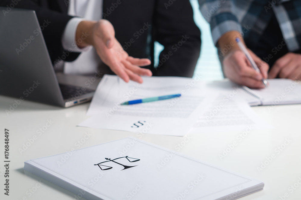Team in law firm working in office. Lawyers discussing and writing. Business people having legal meeting. Pile of paper on table with scale and justice symbol. Team in law firm working in office. Lawyers discussing and writing. Business people having legal meeting. Pile of paper on table with scale and justice symbol.