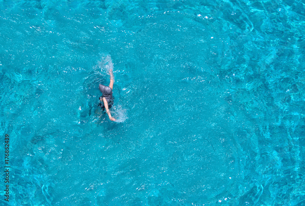 Top angle view of tourist woman swimming.