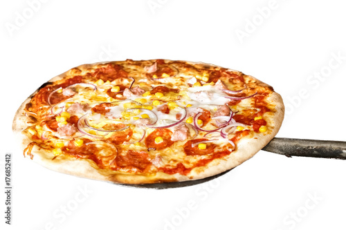 Baked salami pizza on metal paddle isolated on white.