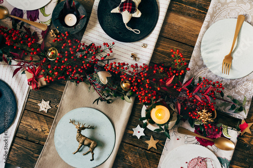 Holiday Gold place setting, funny Christmas table with ornaments and natural berries, on wooden table