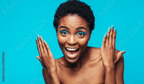 Excited female model showing her vivid makeup