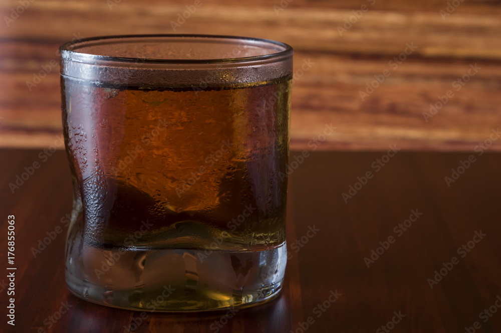 Glass of wiskey and ice on wooden background Glass of wiskey and ice on wooden background