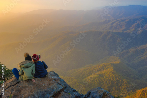 Two tourists are watching the scenery on a beautiful morning light.