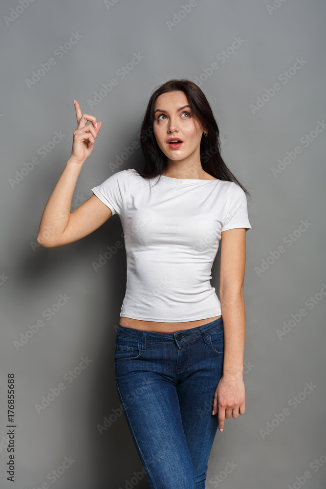 Excited woman shows something, point finger up