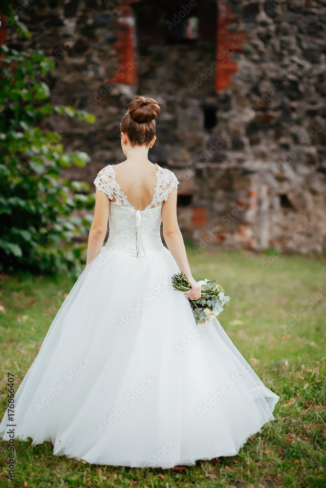 Bride without veils walks near the castle