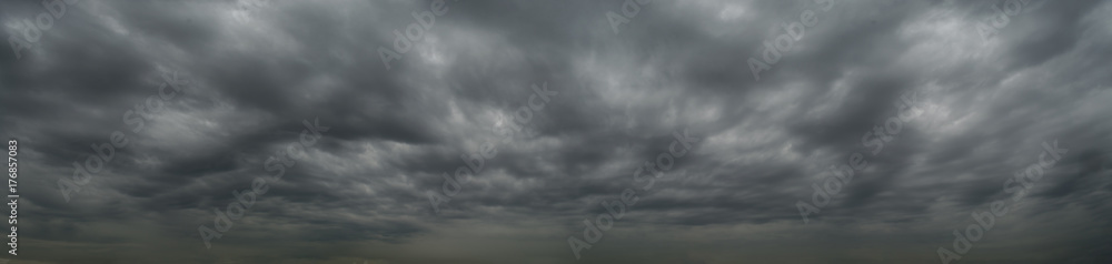 Dark clouds before a thunderstorm, tornado, hurricane, in the vast sky. Dramatic sky background