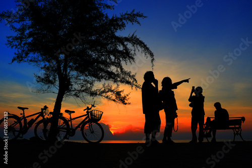 Silhouette family  and bike relaxing with sun  effect on sunrise time at beach